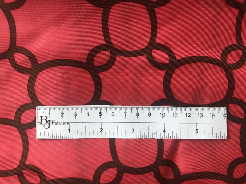 ruler sits on top of red silk twill with brown chain pattern to show scale of print