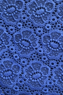flat lay of cobalt heavy guipure lace with floral patterns